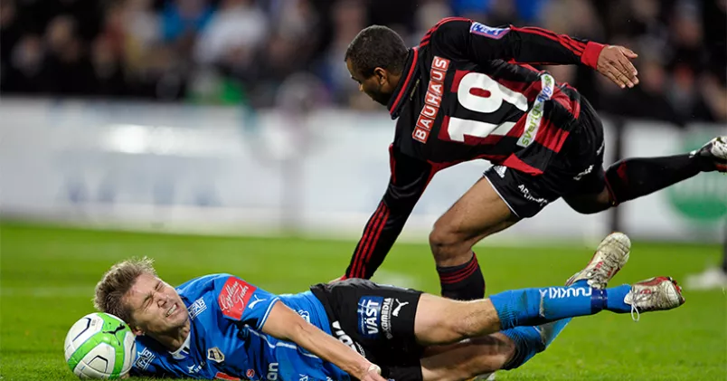 En fotbollsspelares karriär är ofta både kort och hård. Men arbetsvillkoren bör inte vara sämre för det, tycker Unionens förhandlare Stefan Eriksson, som tillsammans med Arbetsgivaralliansen nu kallat in medlare i förhandlingarna om ett nytt fotbollsavtal. På bilden Serge-Junior Martinsson Ngou får Mikael Boman på fall under en match mellan Halmstad och Brommapojkarna på Örjansvall, 2013. Matchen slutade 2-2. Björn Lindgren/TT