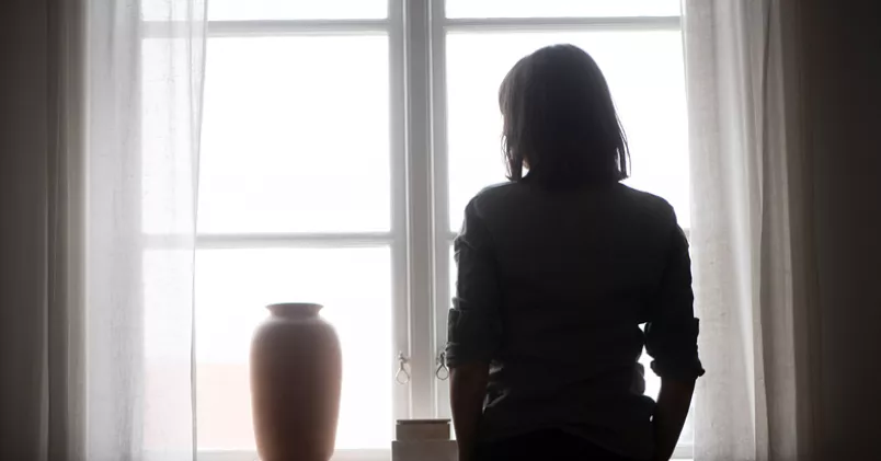 Graden av psykisk ohälsa skiljer sig mycket mellan olika yrkeskategorier. Bland kommunikatörer beror en stor del av sjuktalen på psykisk ohälsa. Siluett av kvinna som tittar ut genom fönstret.
