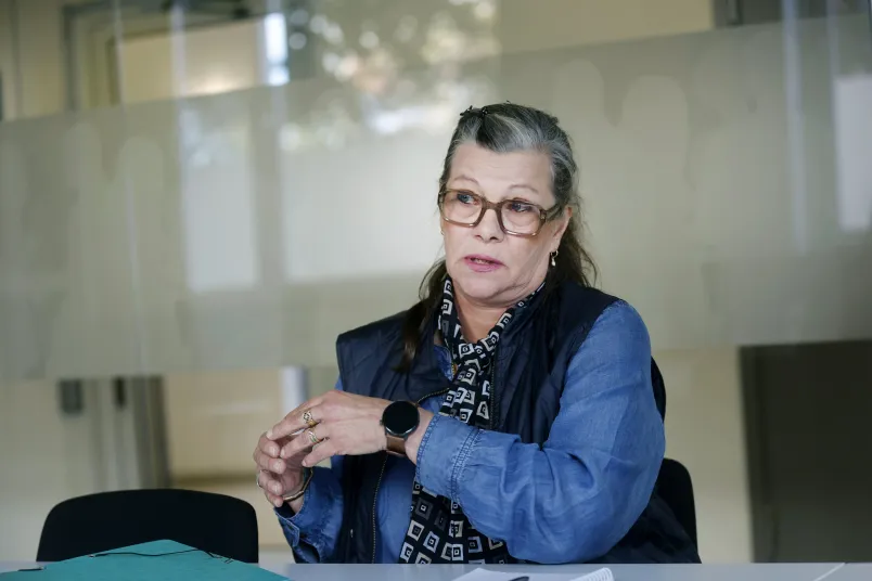 Marie Sjöbom-Olsson Marie Sjöbom-Olsson gestikulerar med händerna. Bär svart väst och blå skjorta.